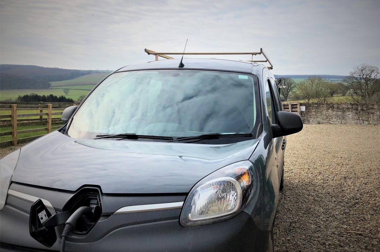 electric car being charged with the countryside in the background